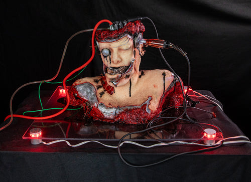 Artificially created figure with electronic components and red lights on a black background